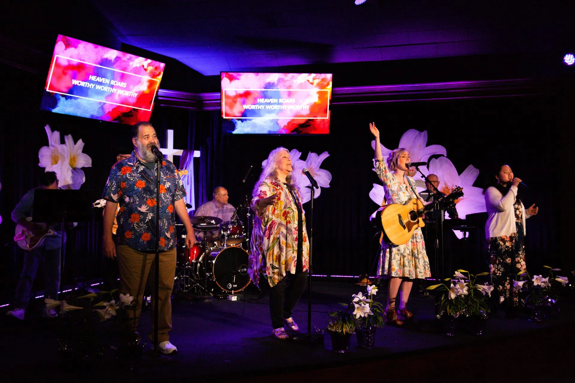 The worship band singing and playing on stage